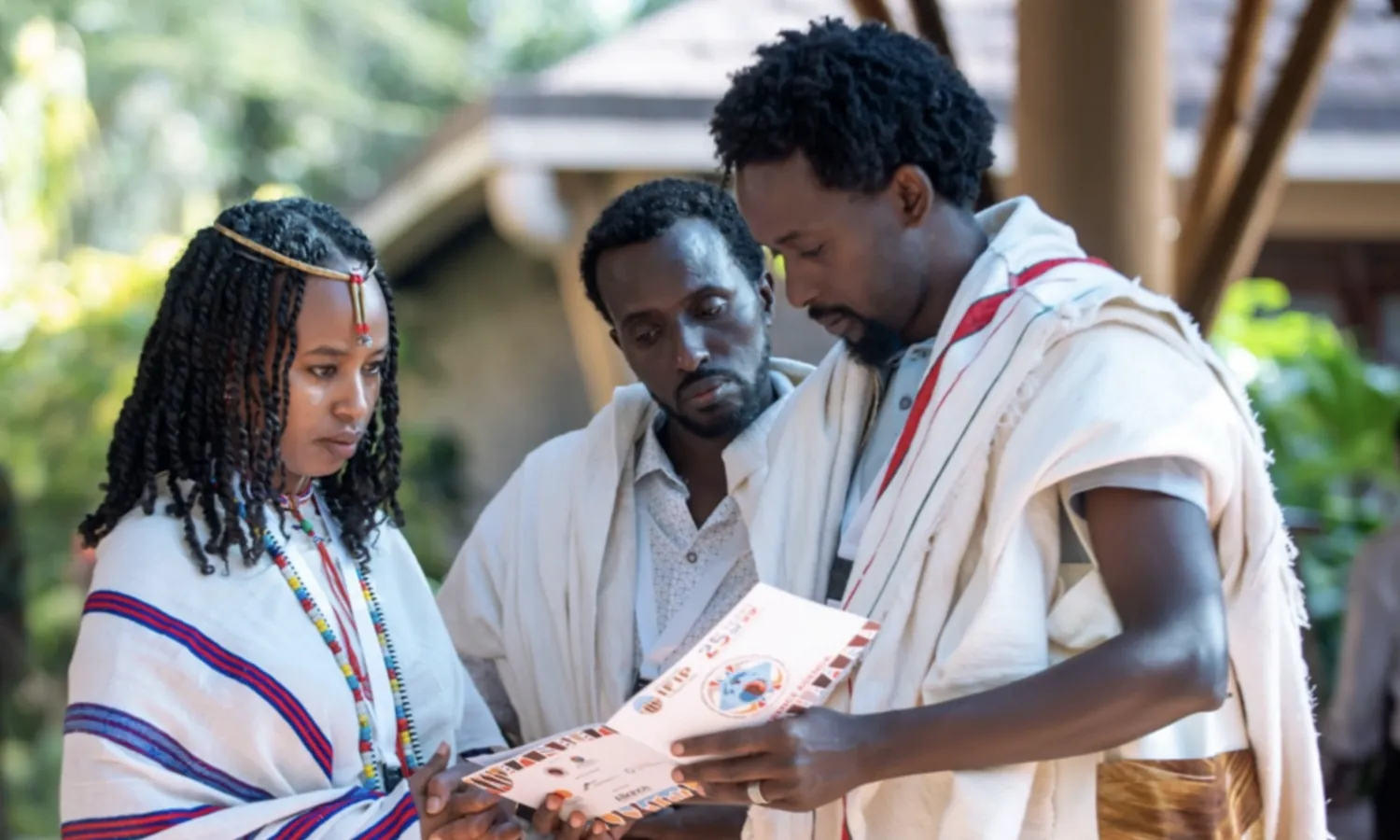 Three people looking at a printed brochure together